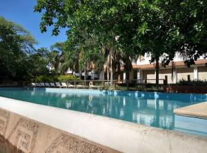 a large swimming pool with trees in the background at Hotel Casino Catamarca in San Fernando del Valle de Catamarca