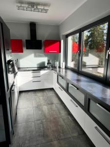 a kitchen with white counters and red cabinets at Dom na Mlaskawce in Istebna +55 photos