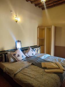Un dormitorio con una cama con almohadas encima. en Sahara Sands Hotel, en Merzouga