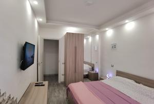 une chambre avec un lit et une télévision à écran plat dans l'établissement porto, à Grado