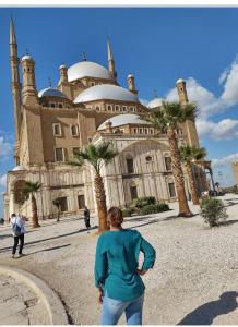 a woman is standing in front of a building at Nana Pyramids Guest House in Cairo