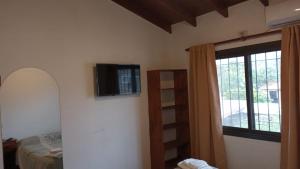 a bedroom with a bed and a television on the wall at Posta Almendros Apart in Merlo
