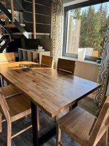 a dining room table with chairs and a large window at Dom na Mlaskawce in Istebna