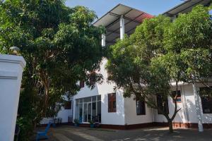 un edificio bianco con alberi di fronte di Azure Resort Mirissa a Mirissa