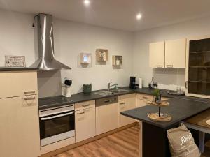 a kitchen with white cabinets and a black counter top at Ferienwohnung Burgunderwiese in Bad Neuenahr-Ahrweiler