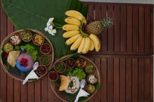 un tavolo con due piatti di cibo e un mucchio di banane di Azure Resort Mirissa a Mirissa