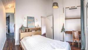 a bedroom with a large bed and a chair at Villa des Acacias avec piscine chauffée pour 15 personnes entre lac et océan Wifi gratuit in Hossegor +17 photos