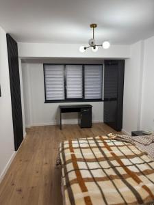 a bedroom with a bed and a desk and a window at Garsonieră Park Residence Vâlcea in Râmnicu Vâlcea