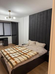 a bedroom with a large bed with a black headboard at Garsonieră Park Residence Vâlcea in Râmnicu Vâlcea