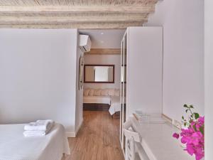 a small room with a bed and a dressing table at La Maison Kalogera in Mikonos