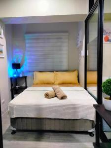 - un lit avec 2 serviettes dans une chambre dans l'établissement 2 BEDROOM CONDO close to SM Tungko BULACAN ideal for Family Queen bed on Bedroom 1 accessible to Bedroom 2 with sliding doors Free Wifi & Netflix to watch in a comfy sofa & twin bed Access to SWIMMING POOL entry is very affordable and kids get for free, à Tunkong Manga