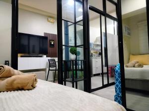 Ένα ή περισσότερα κρεβάτια σε δωμάτιο στο 2 BEDROOM CONDO close to SM Tungko BULACAN ideal for Family Queen bed on Bedroom 1 accessible to Bedroom 2 with sliding doors Free Wifi & Netflix to watch in a comfy sofa & twin bed Access to SWIMMING POOL entry is very affordable and kids get for free