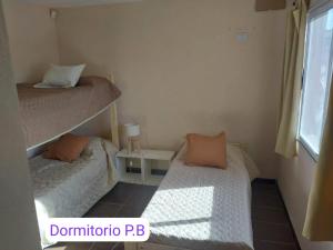 a bedroom with two bunk beds and a window at Cabaña Lago y Luna in Villa Ciudad Parque