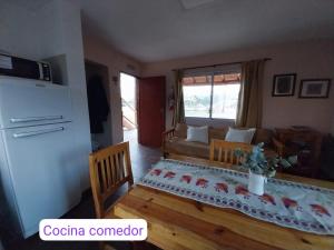 a living room with a table and a couch at Cabaña Lago y Luna in Villa Ciudad Parque +10 photos