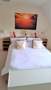 ein großes weißes Bett mit weißer Bettwäsche und Kissen in der Unterkunft Ennis Lodge - Golf Village at Lough Erne Resort in St Angelo
