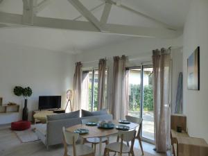 a living room with a couch and a table at HOSSEGOR PLAGE- Villa PAUL -Petite villa rénovée pour 4 personnes- Wifi gratuit in Hossegor