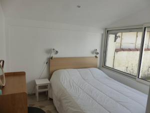 a bedroom with a bed and a window at HOSSEGOR PLAGE- Villa PAUL -Petite villa rénovée pour 4 personnes- Wifi gratuit in Hossegor