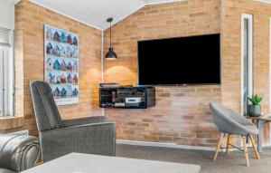 a living room with a brick wall with a flat screen tv at Holiday Home Mettes Bjerg Hvide Sande Iv in Hvide Sande