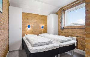 two beds in a room with a brick wall at Holiday Home Mettes Bjerg Hvide Sande Iv in Hvide Sande +20 photos
