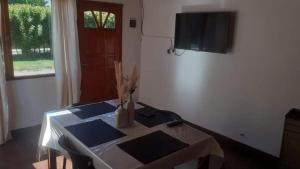 a room with a table and a television on a wall at departamento por día ruta 41 2 in Los Antiguos