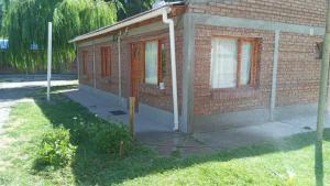 a brick building with a porch and a window at departamento por día ruta 41 2 in Los Antiguos