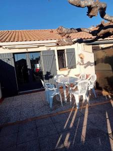a white table and chairs in front of a house at résidence les amandines in Gruissan