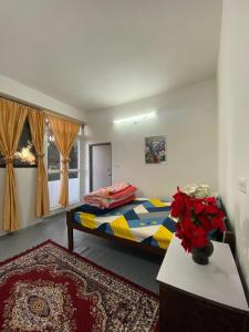 a bedroom with a bed and a vase of flowers on a table at Samendo-Retreat Homestay in Sukhia Pokhari