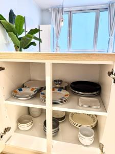 un armario lleno de platos y cuencos en Beautiful 2 bedroom familiar luxury apartment, en Bruselas