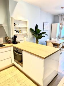 Una cocina con gabinetes blancos y una encimera de madera. en Beautiful 2 bedroom familiar luxury apartment, en Bruselas