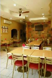 comedor con mesas y sillas de madera en Hotel California en Tuxpan de Rodríguez Cano
