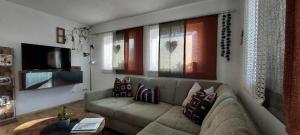 a living room with a couch and some windows at Haus Adrian in Wald am Arlberg
