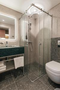 a bathroom with a glass shower and a toilet at Yourta in Uralsk