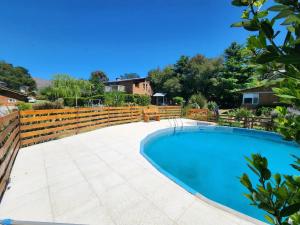 a swimming pool in a backyard with a fence at Altitud 410 in Villa Ventana