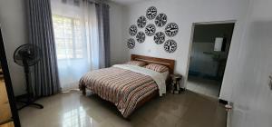 a bedroom with a bed and a bathroom with a shower at Private cosy home close to city center with views in Kigali