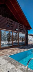 ein Haus mit einem Swimmingpool vor einem Gebäude in der Unterkunft Bujtina Gentiana in Peja