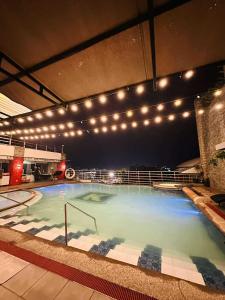 a large swimming pool with lights in a building at Angeles City Apartment in Santol