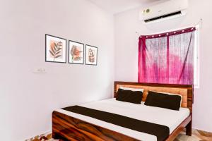 a bedroom with a bed and a pink window at Hotel O Pragati Resort Marriage Hall & Restaurant in Gorakhpur