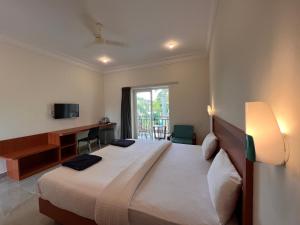 Una televisión o centro de entretenimiento en Morjim Sunset Hotel - 400 meter to Morjim Beach