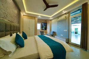 a bedroom with a large bed with blue pillows at Tranquil Trails- Holiday Homes-Dehradun in Dehradun