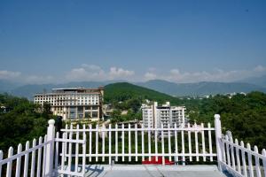 a white fence with a view of a city at Tranquil Trails- Holiday Homes-Dehradun in Dehradun