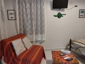 a bedroom with a bed and a table and a tv at Roppas Studios Nostos in Kato Gatzea