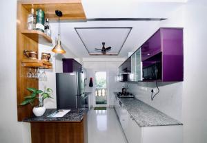 a kitchen with purple cabinets and a counter top at Tranquil Trails- Holiday Homes-Dehradun in Dehradun