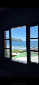 una ventana con vistas al océano desde una casa en Cabana Solitude - Concha, en Florianópolis