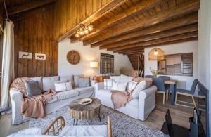 a living room with two couches and a table at Casa Catania-Acogedora casa con impresionantes vistas-Fibra Optica-5 TV-Aire ACondicionado in Salardú
