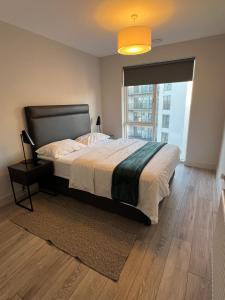 Un dormitorio con una cama grande y una ventana grande. en Spacious shared apartment with private Bathroom Dublin, en Lucan