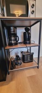 a shelf with pots and pans and a microwave at Burgau Apartments Modern & Renovated in Jena