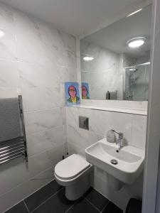 Un baño blanco con inodoro y lavabo. en Spacious shared apartment with private Bathroom Dublin, en Lucan