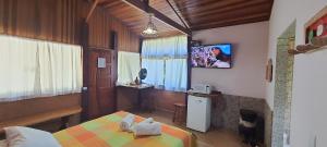 a bedroom with a bed and a tv on the wall at Pousada Estalagem Mirante in Aiuruoca
