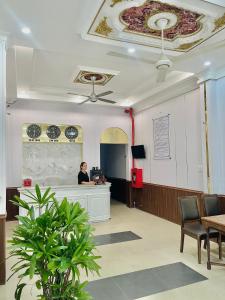 a woman standing at a counter in a waiting room at Amy Hotel Hue in Hue