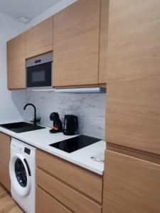 a kitchen with a sink and a microwave at Le Strasbourgeois Moderne & Neuf Voyage en Alsace in Strasbourg